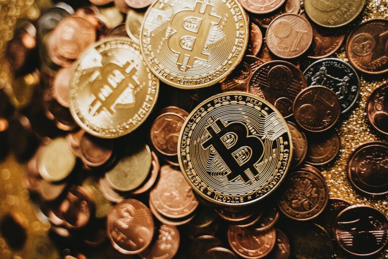 A detailed close-up of shiny bitcoins and assorted coins symbolizing digital currency and wealth.