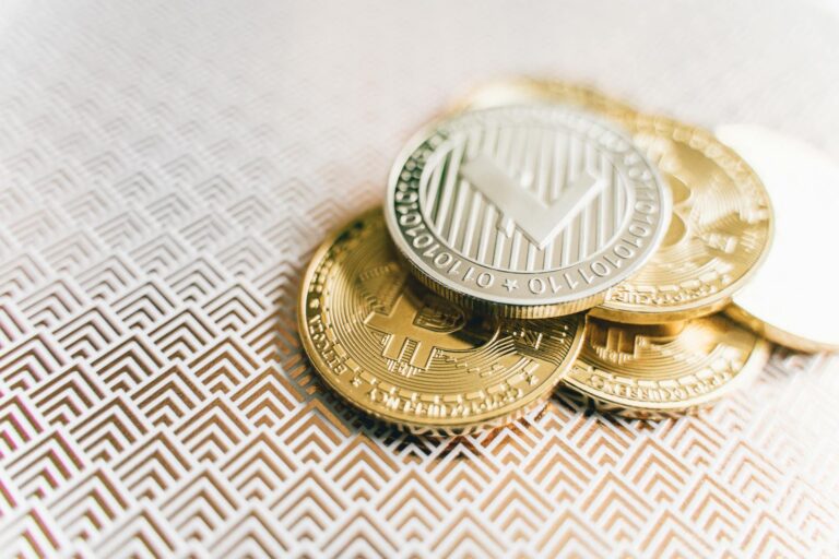 Stack of Bitcoin and Litecoin coins on a geometric textured surface, symbolizing digital finance.
