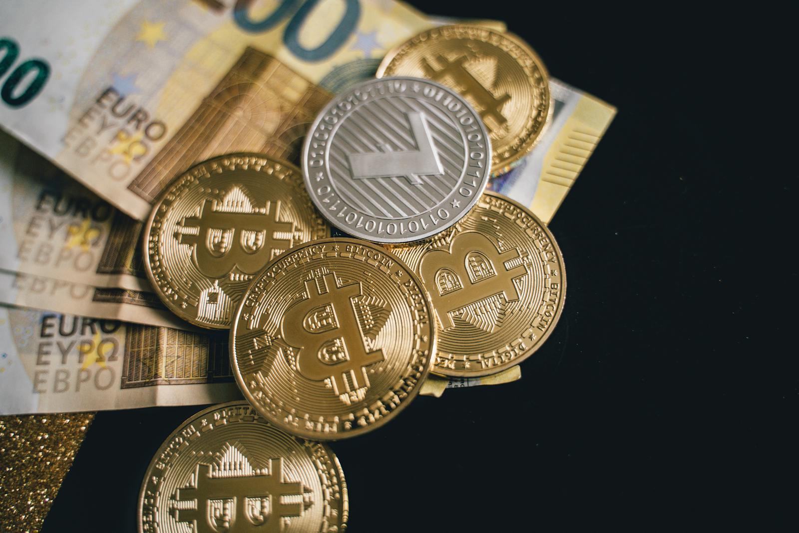 Close-up of bitcoins and euro banknotes, representing modern finance and digital currency exchange.